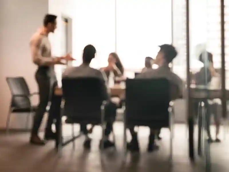 A blurred photo of colleagues having meeting in boardroom.